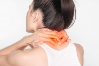 woman with neck pain. Female holding hand to spot of neck. Concept photo with read spot indicating location of the pain. Health-care concept