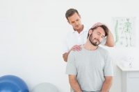 Male chiropractor doing neck adjustment in the medical office
