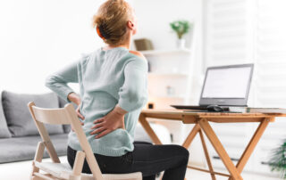 woman infront of her laptop showing signs of hip pain