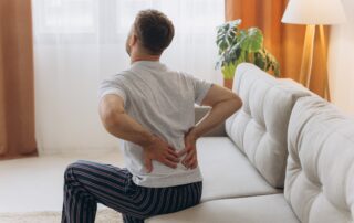 Back,View,Of,Man,Wearing,White,Pajamas,Sitting,On,Sofa