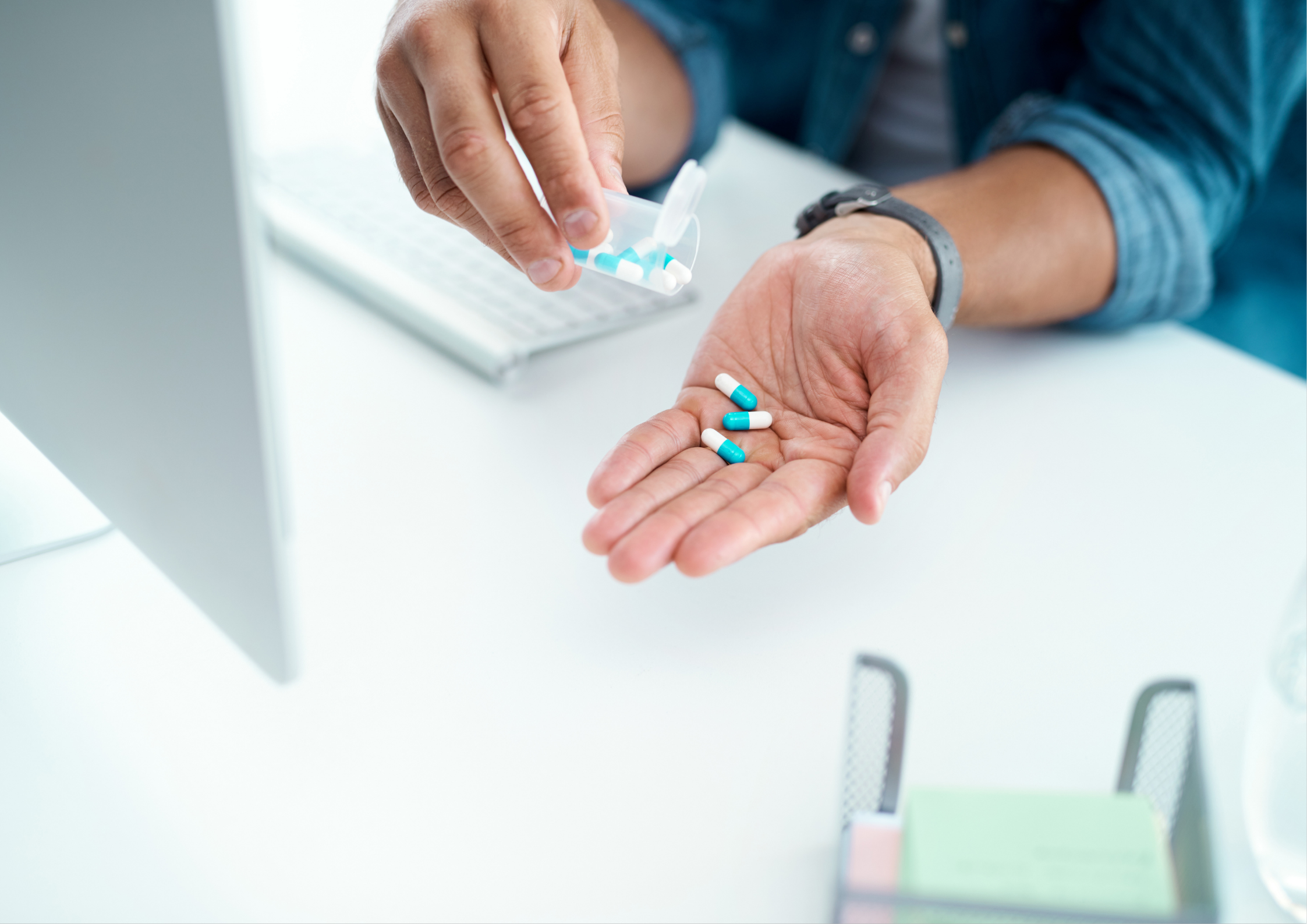shot of unrecognizable businessman taking his medication in his office